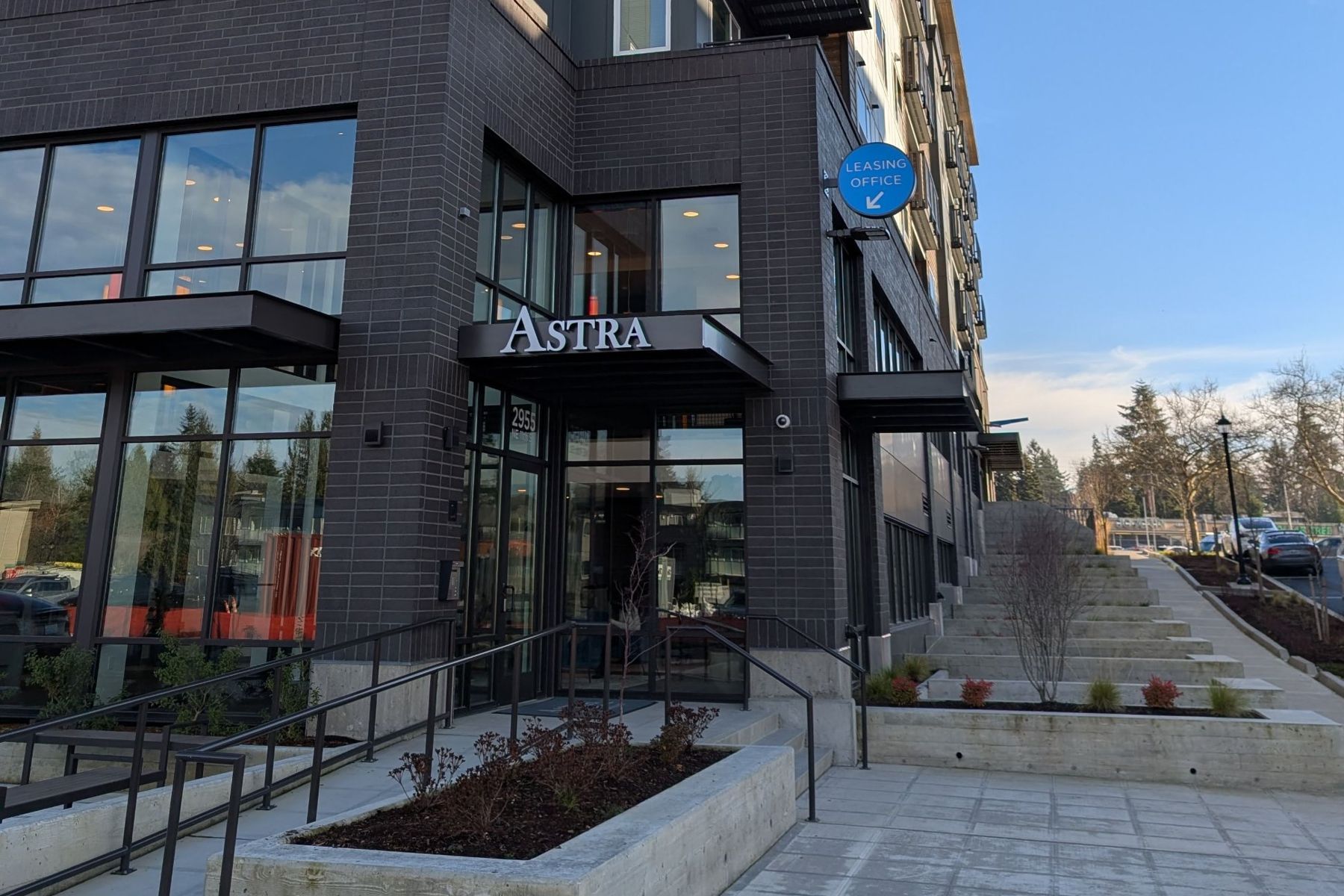 Astra residential entrance with brick base, landscaped planters and leasing office sign