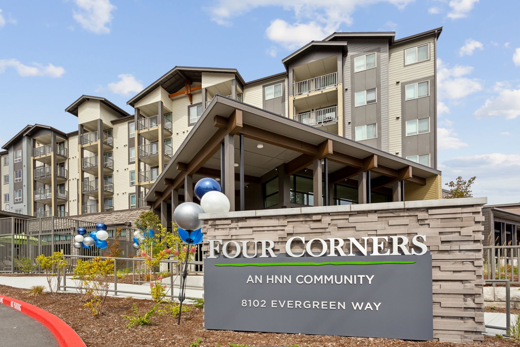 Four Corners apartments behind its stone entry sign