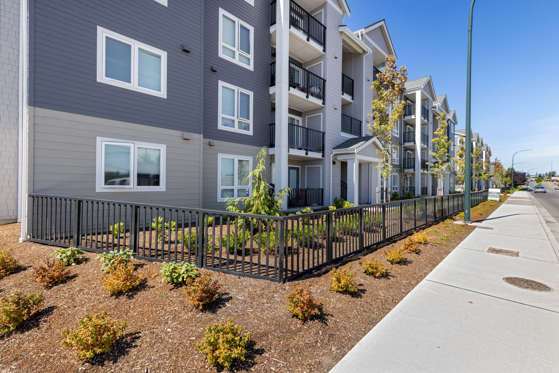 Riverview apartments with landscaped frontage along the sidewalk